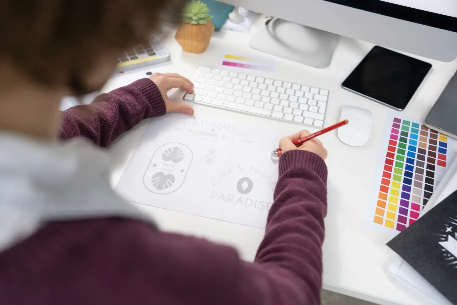 Bocetos de logotipo sobre una mesa de trabajo